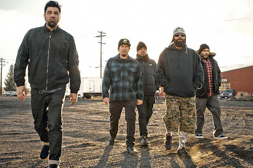 la banda Deftones posando ante la cámara en un terreno arenoso
