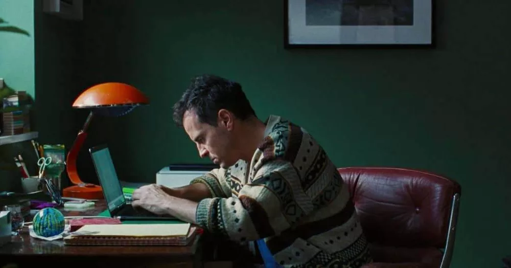 andrew scottt protagonista de todos somos extraños recargado en su escritorio