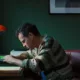andrew scottt protagonista de todos somos extraños recargado en su escritorio